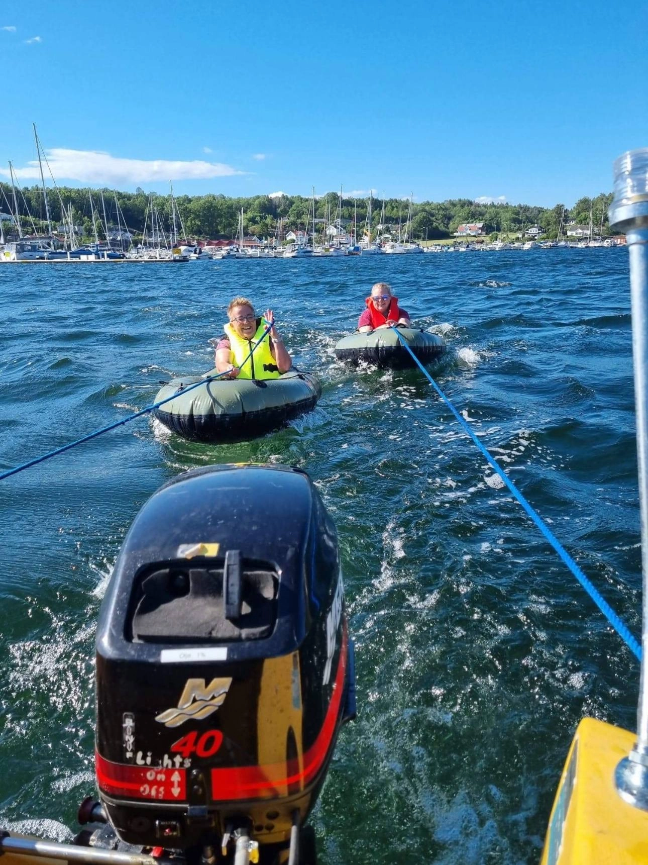 Two young geocachers being towed in swim rings behind a motorboat during a T5 water event.