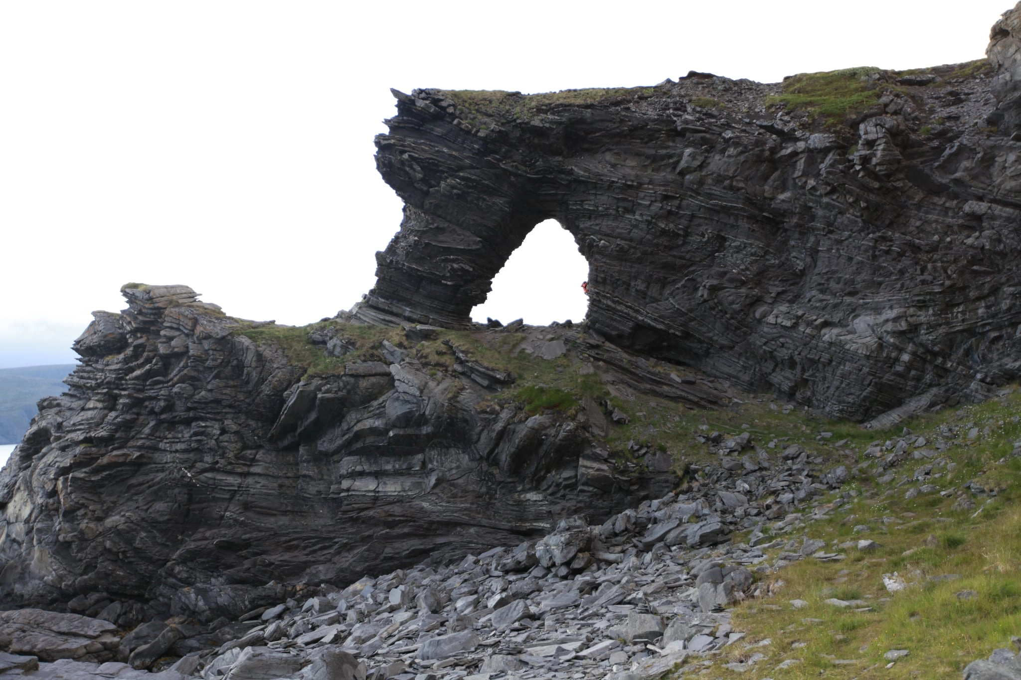 Kirkeporten, a natural rock formation near the North Cape, viewed under cloudy skies.