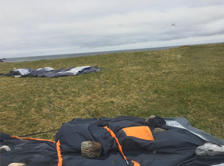 Collapsed tent weighed down with stones after a stormy night.
