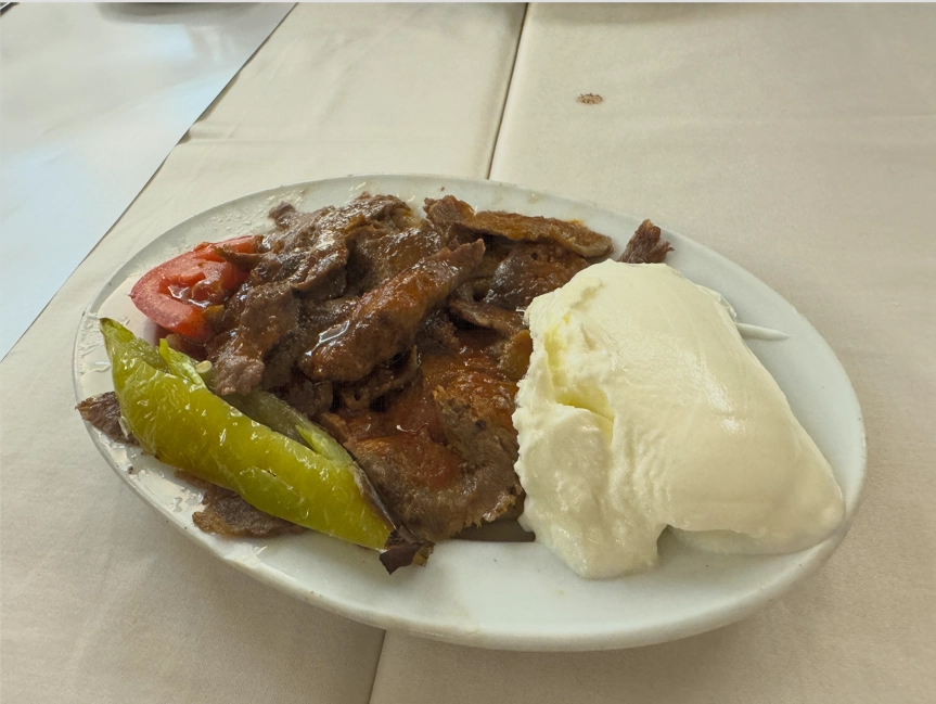 Plate of Iskender Kebab with lamb, tomato sauce, butter, and yogurt